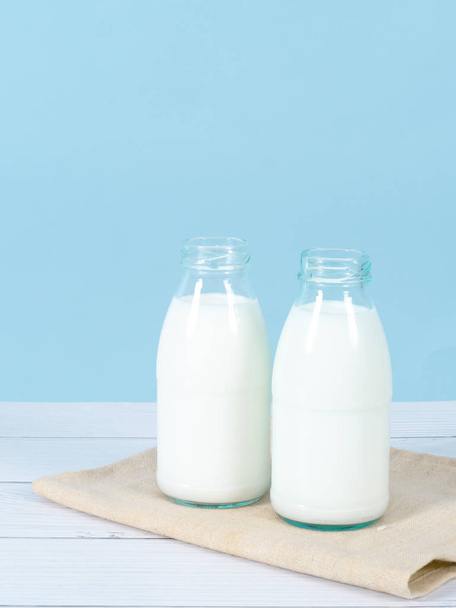 Milk bottle on table with blue background. - Foto, imagen