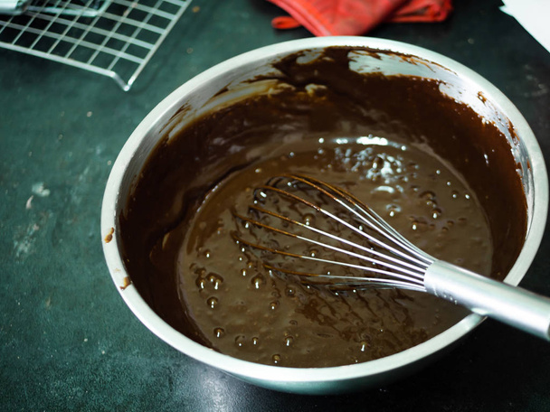 Chocolate butter cream in big bowl, processing cupcakes. - Photo, Image