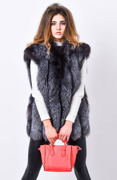 Female fashion model hold purse. Girl fashion lady stylish hairstyle wear mink fur coat. Fashion stylish accessory. Fashion and shopping concept. Woman in fur coat with handbag on white background - Fotó, kép