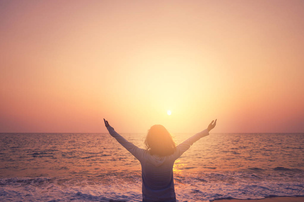 Kopie Raum der Frau steigen Hand nach oben auf Sonnenuntergang Himmel am Strand und Insel Hintergrund. - Foto, Bild