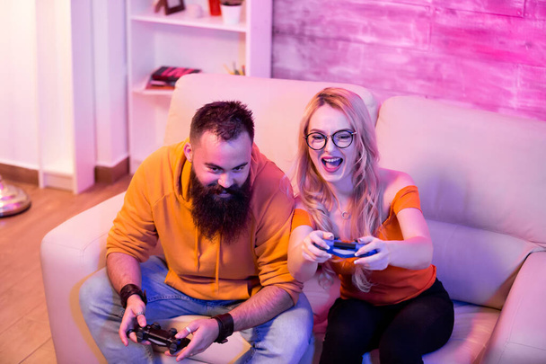 Competitive couple playing video games on console - 写真・画像