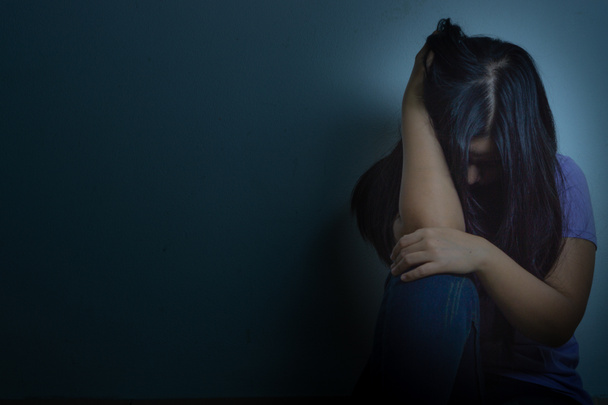 Üzgün kadın, karanlık bir odada tek başına otururken dizine sarılıp ağlar. Dep. - Fotoğraf, Görsel