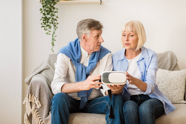Modern senior couple testing VR glasses device - 写真・画像