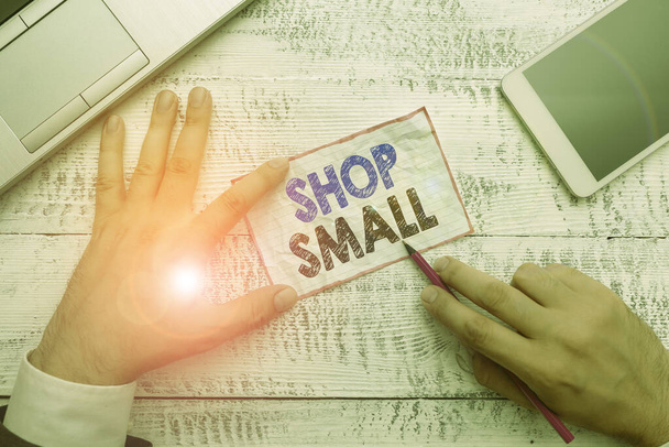 Szóírás szöveg Shop Small. Üzleti koncepció az országos mozgalom számára, amely minden nap ünnepli a kisvállalkozásokat Kézi jegyzetfüzet az íróeszközök és a modern okostelefon-készülék közelében. - Fotó, kép