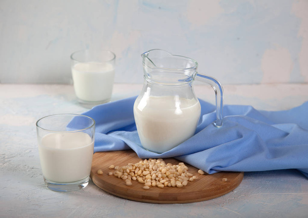 Vegetarian pine nut milk in glass cups and jug, on white background. horizontal - Foto, afbeelding