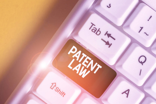 Text sign showing Patent Law. Conceptual photo deals with an inventor s is exclusive right to use own invention White pc keyboard with empty note paper above white background key copy space. - Photo, Image