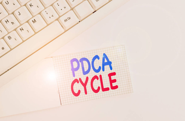 Χειρόγραφο κείμενο γραφής Pdca Cycle. Έννοια που σημαίνει χρήση για τον έλεγχο και τη συνέχιση της βελτίωσης των διαδικασιών και των προϊόντων Λευκό πληκτρολόγιο PC με άδειο χαρτί σημείωμα πάνω από το λευκό φόντο. - Φωτογραφία, εικόνα