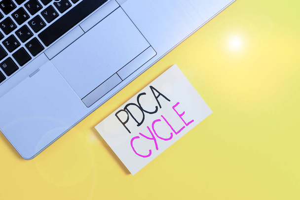 Word writing text Pdca Cycle. Business concept for use to control and continue improve the processes and products Slim trendy silver open laptop square sticky notepad colored background. - Photo, Image