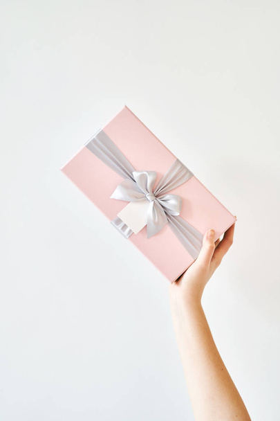 Ένα κορίτσι κρατά ένα κουτί δώρου σε λευκό φόντο - Φωτογραφία, εικόνα