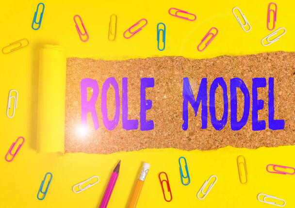 Conceptual hand writing showing Role Model. Business photo text a demonstrating looked to by others as an example to be imitated Stationary and torn cardboard on a wooden classic table backdrop. - Photo, Image