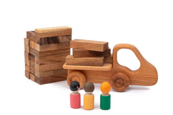 Het houten speelgoed van de truck bracht het bouwmateriaal in de vorm van houtblokken naar de bouwplaats. Beelden van bouwers van kinderspeelgoed. Concept bouwplaats - Foto, afbeelding