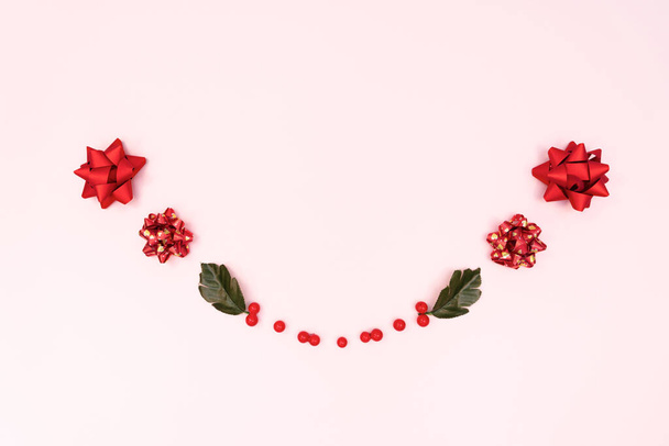 Christmas wreath on pink background. Christmas decoration. Flat lay, top view, copy space - 写真・画像