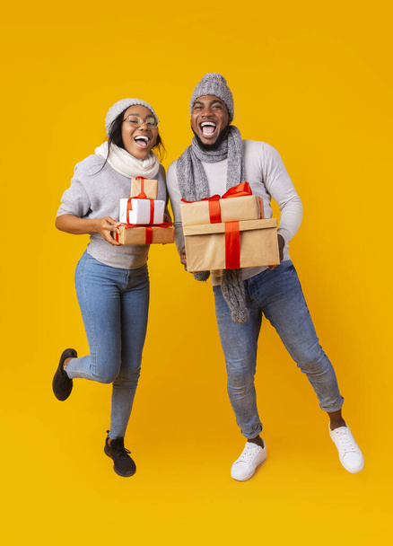 Super happy afro couple with Christmas presents - 写真・画像