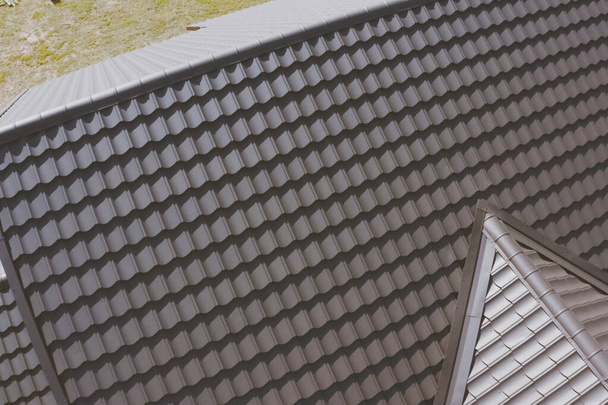 Кахельна плитка коричневого металу на даху будинку. Гофрований металевий дах
 - Фото, зображення