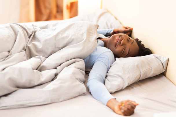 Afro tyttö venyttely kädet herääminen sängyssä kotona
 - Valokuva, kuva