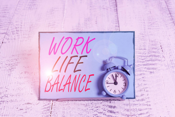 konzeptionelle Handschrift, die Work-Life-Balance zeigt. Geschäftsfoto zeigt die Aufteilung der Zeit zwischen Arbeit oder Familie und Freizeit-Wecker, der über Pufferdraht vor dem Notizblock gekippt ist. - Foto, Bild