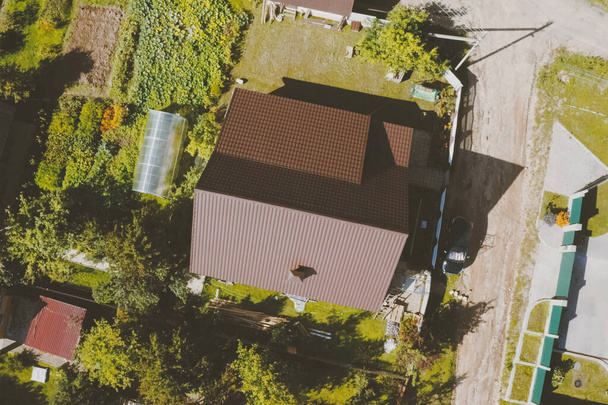 Brown metal tile on the roof of the house. Corrugated metal roof - Photo, Image