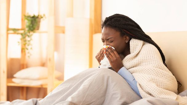Malade noir fille soufflant nez assis dans le lit, Panorama
 - Photo, image