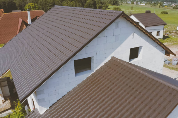 Telha de metal marrom no telhado da casa. telhado de metal ondulado
 - Foto, Imagem