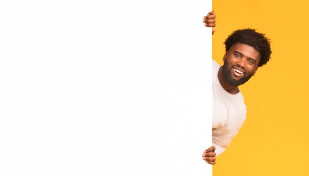 Улыбающийся чёрный парень смотрит на большую белую доску
 - Фото, изображение