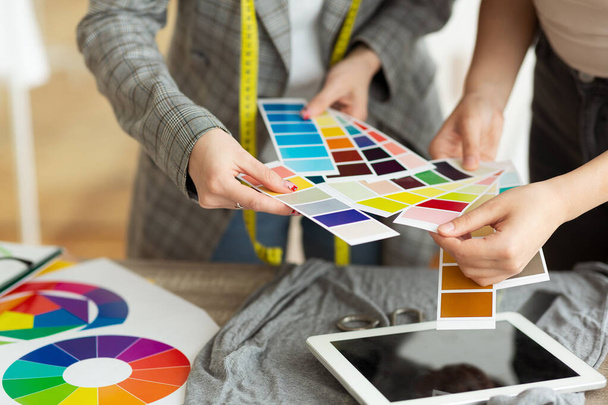 Модный дизайнер выбирает образцы цветов в ателье
 - Фото, изображение