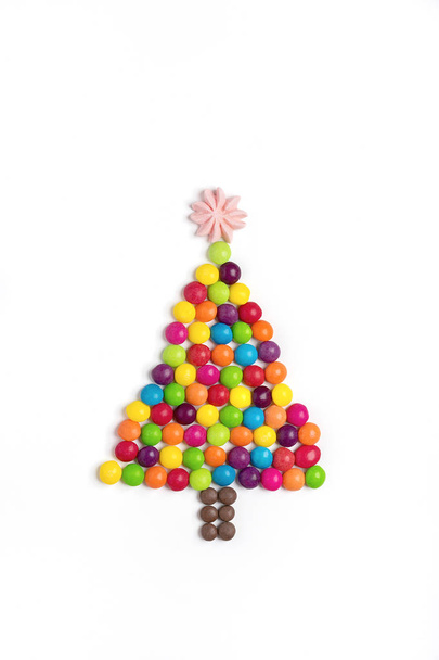  Christmas tree made of Mix colorful chocolate candy, star made of meringue isolated on white background Holiday card Happy new year, party, minimal concept Top view Flat lay Place for text Copy space - Fotografie, Obrázek