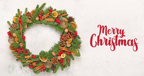 Beautiful wreath and text MERRY CHRISTMAS on light background - Valokuva, kuva