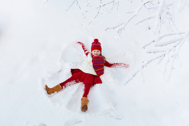 雪の天使を作る子供。子供冬の屋外の楽しみ. - 写真・画像