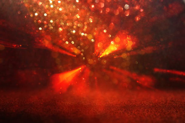 achtergrond van abstracte rode, gouden en zwarte glitter lichten. gedeconcentreerd - Foto, afbeelding