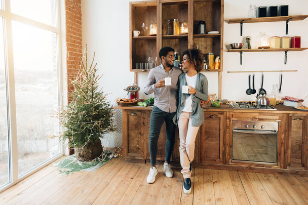 Afro-Amerikaanse paar samen koffie drinken in de keuken - Foto, afbeelding