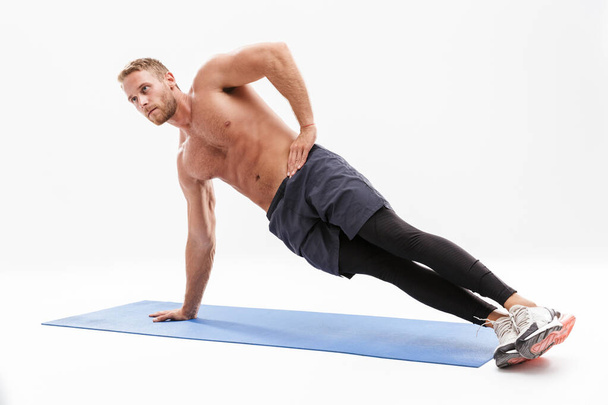 Confident attractive sportsman doing plank exercise - Fotó, kép