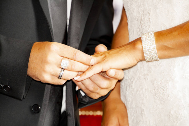 La mano del hombre poniendo el anillo de bodas en la mano de una mujer
  - Foto, Imagen