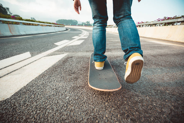 Skateboarder riding board on city street asphalt - Fotó, kép