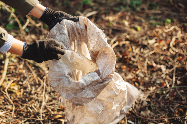 Ekoaktivisti poimii likaisia muovipulloja puistosta. Nainen ha
 - Valokuva, kuva