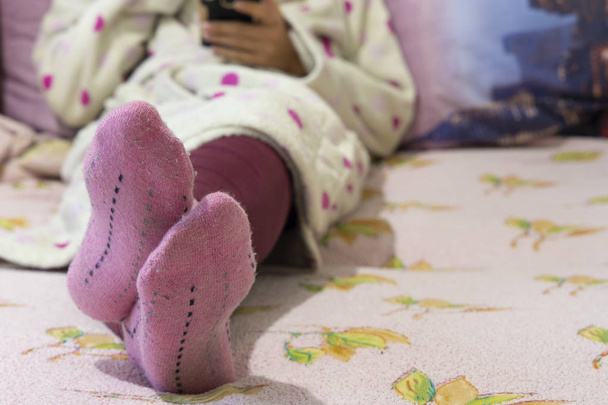 одинокая женщина лежала на кровати в халате и розовых теплых носках, утренние выходные ленивые обои время крытый рисунок с пустым местом для копирования текста здесь
  - Фото, изображение