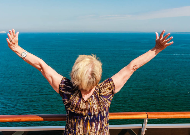Mujer feliz libre mirando al océano en pose de libertad feliz con el brazo
 - Foto, imagen