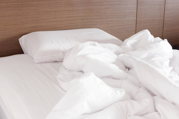 Lenzuolo bianco stropicciato e cuscini disordinati in una camera d'albergo
 - Foto, immagini
