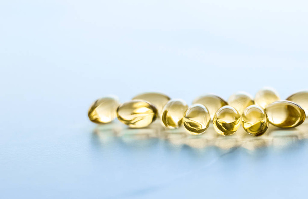 Βιταμίνη D και χρυσά χάπια Omega 3 για την υγιεινή διατροφή, f - Φωτογραφία, εικόνα