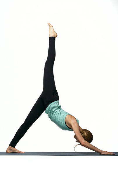 Retrato de una joven atractiva haciendo ejercicios sobre esterilla de yoga. Estilo de vida saludable y concepto deportivo. Serie de poses de ejercicio. Aislado sobre blanco
 - Foto, Imagen