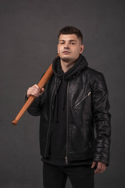 The young gue wearing leather jacket holding baseball bat in his - Photo, Image