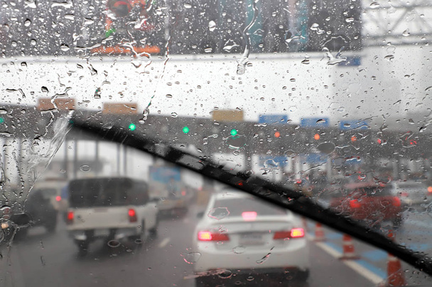Pohled zepředu na jízdu se stěrači předního skla v deštivém dni na mýtné bráně. - Fotografie, Obrázek