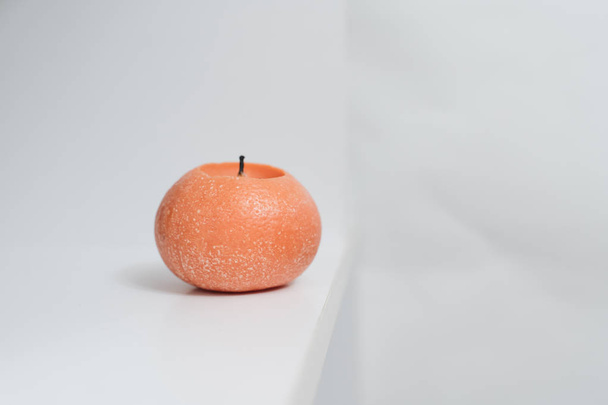 orange round candle in white interior  - Zdjęcie, obraz