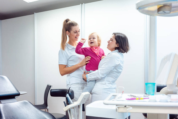 Dentist and her assistant with child in the office - Foto, Imagem