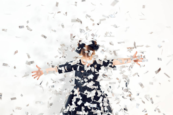 Party, holidays, new year and celebration concept - Female child throwing confetti. - Фото, изображение