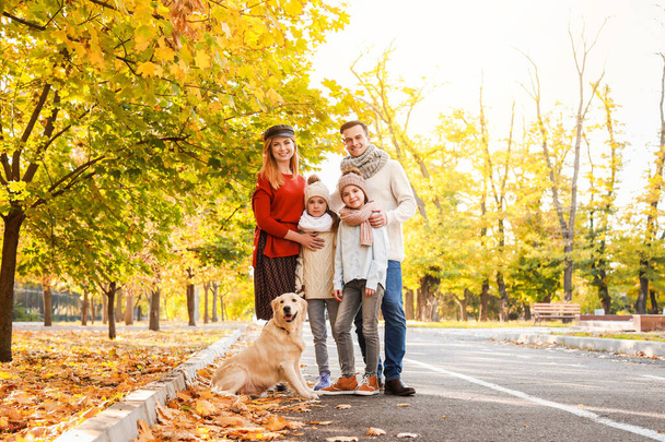 Onnellinen perhe koiran kanssa syksyllä puistossa
 - Valokuva, kuva