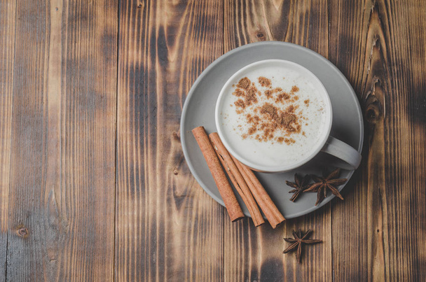 Eggnog. Traditional christmas cocktail in a cup and cinnamon sti - Фото, зображення