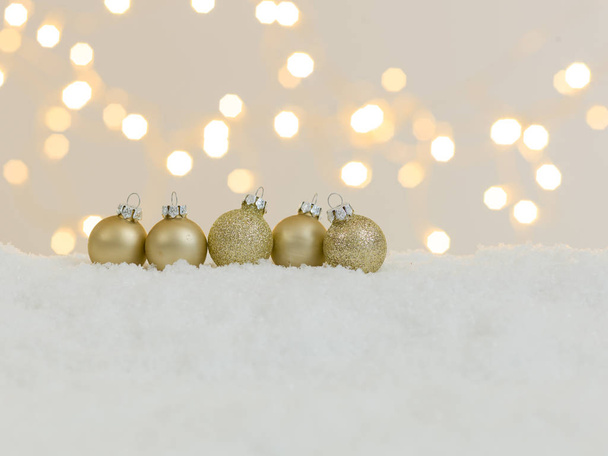collezione di articoli natalizi dorati su neve bianca con luci brillanti sullo sfondo
 - Foto, immagini