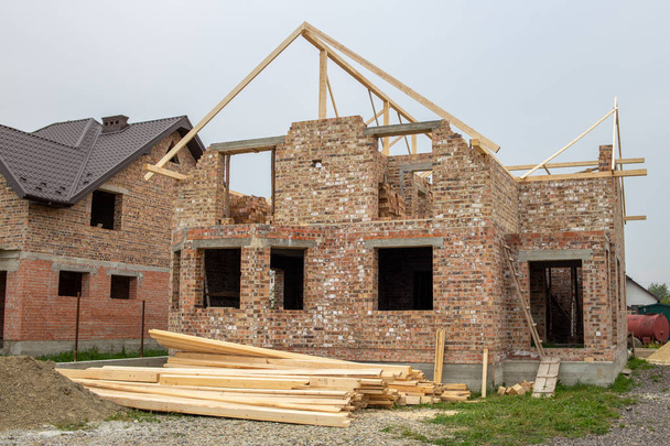 Casa de ladrillo sin terminar con estructura de techo de madera bajo construc
 - Foto, Imagen