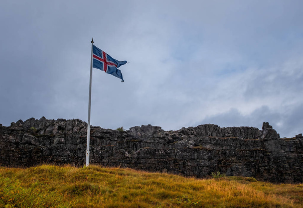 Izland, Aranygyűrű terület, a Thingvellir Nemzeti Park tájai izlandi zászlóval. 2019. szeptember - Fotó, kép