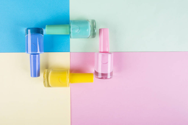 Multi-colored nail polishes on a colorful background - Fotografie, Obrázek